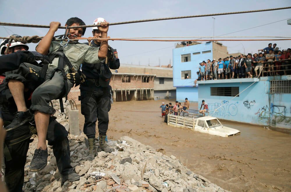 Rescue workers pull a man to safety in Lima, Peru, Friday, March 17, 2017. Intense rains and mudslides over the past three days have wrought havoc around the Andean nation and caught residents in Lima, a desert city of 10 million where it almost never rains, by surprise. (AP Photo/Martin Mejia)