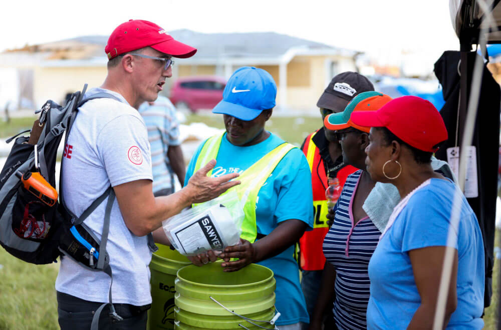 Convoy of Hope team member provides instructions on the Sawyer Water Filters being distributed in the Bahamas
