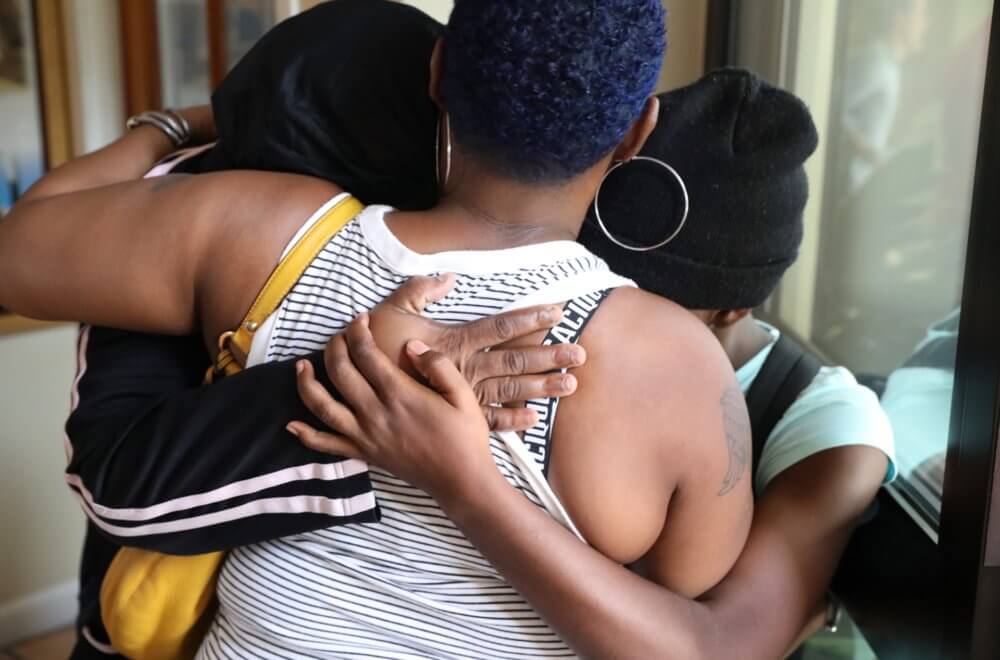 Family members comfort one another after Hurricane Dorian destroyed their neighborhood. (Photo/Jess Heugel)