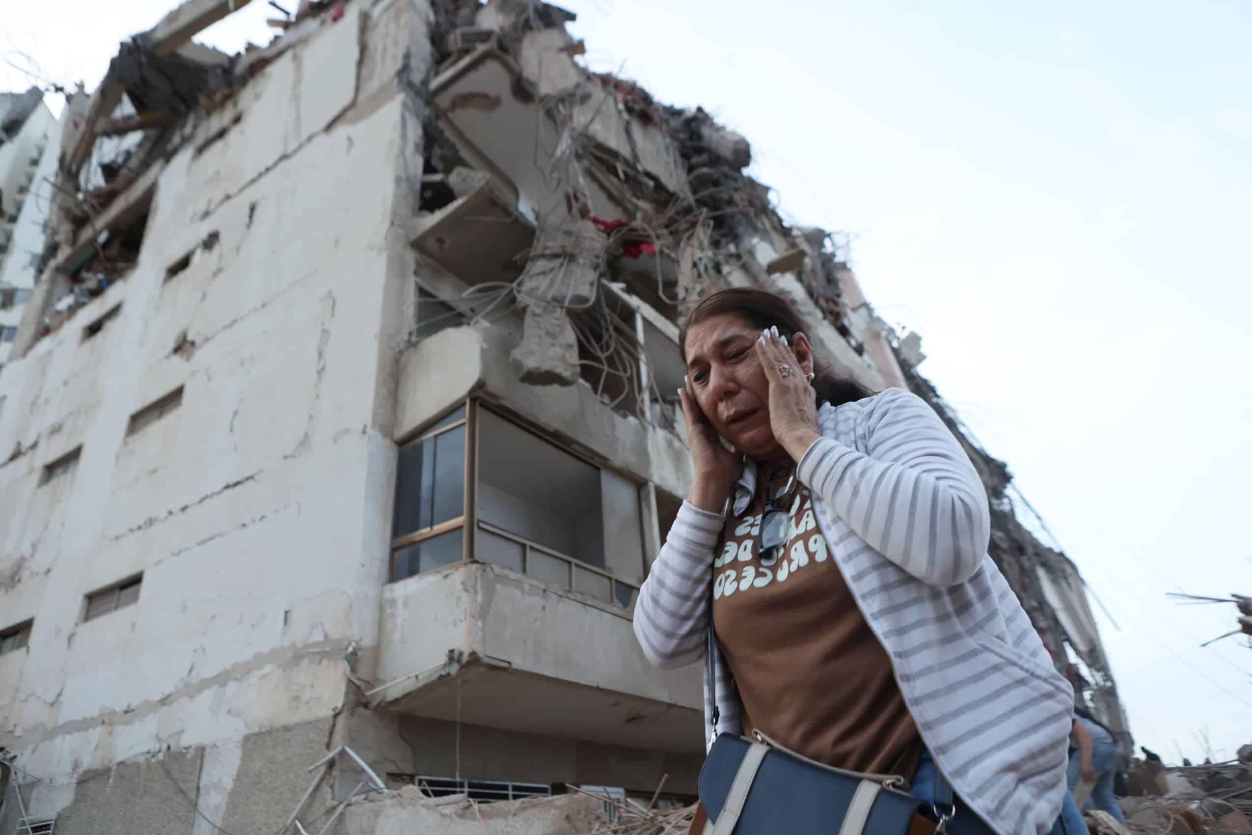 A woman walks past a building damaged during an earthquake in La Guaira, Venezuela, Thursday, June 25, 2026. (AP Photo/Pedro Mattey)