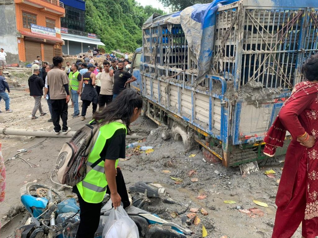 A Convoy teammate, while distributing essential relief supplies to survivors and responders, steps over a motorbike that is stuck in the mud.